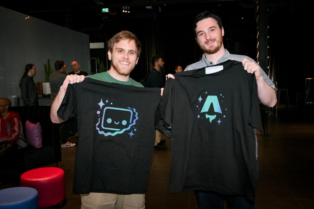 Two Astro maintainers holding up black t-shirts. One is Houston and the other the Astro logo.