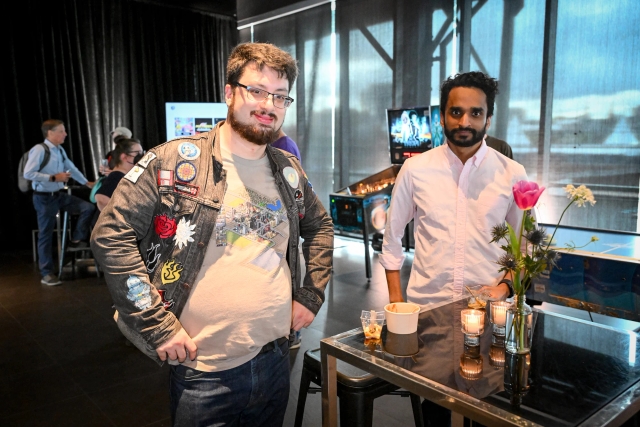 Two guests pose next to a high table with their food.