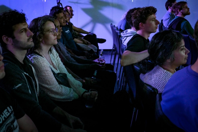 A shot of a row of audience members listening intently to the keynote presentation.