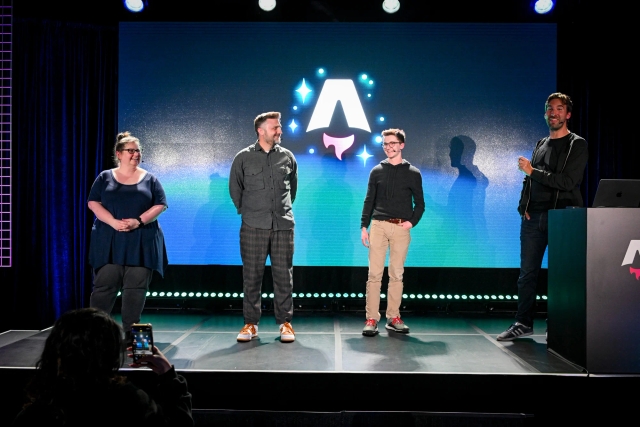 Keynote speakers on stage. From left to right: Sarah Rainsberger, Matthew Phillips, Ben Holmes, and Fred K. Schott (next to the podium). 