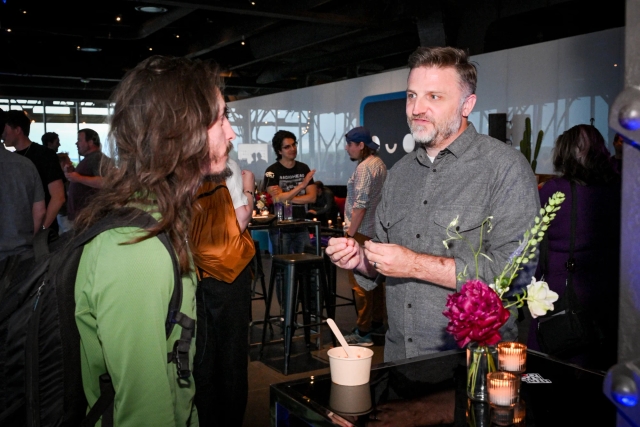 Matthew Phillips speaks to a guest as the guest eats his appetizer.