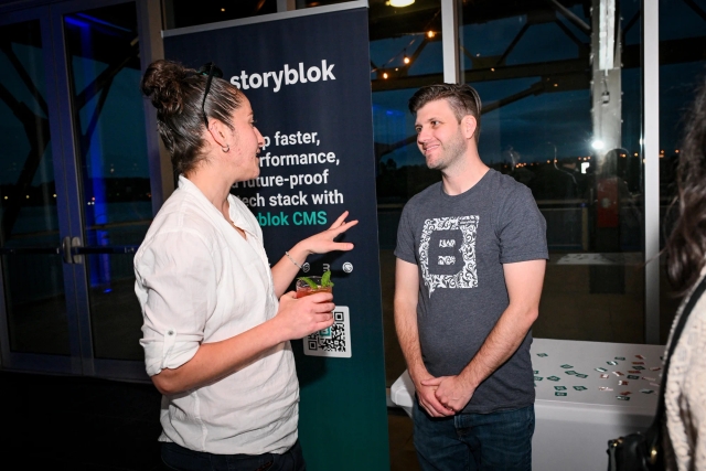 Storyblok explaining their product to a guest at their sponsor booth.